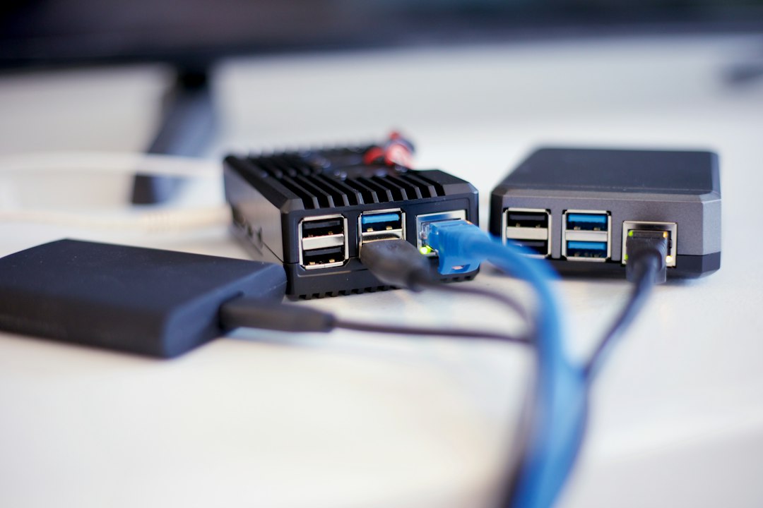 Dois pequenos computadores de placa única com cabos de rede e USB conectados, ao lado de um disco externo sobre uma mesa branca.